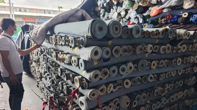 Vải denim cuộn xếp chồng tại khu bán sỉ trong chợ vải, 5/2026.