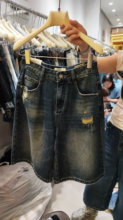 Mẫu quần short jean treo trên móc tại một showroom sỉ quần jean, 5/2026.