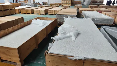 Tấm đá mềm xếp trong kiện gỗ, phủ màng bảo vệ khi đóng gói tại kho, 5/2026.
